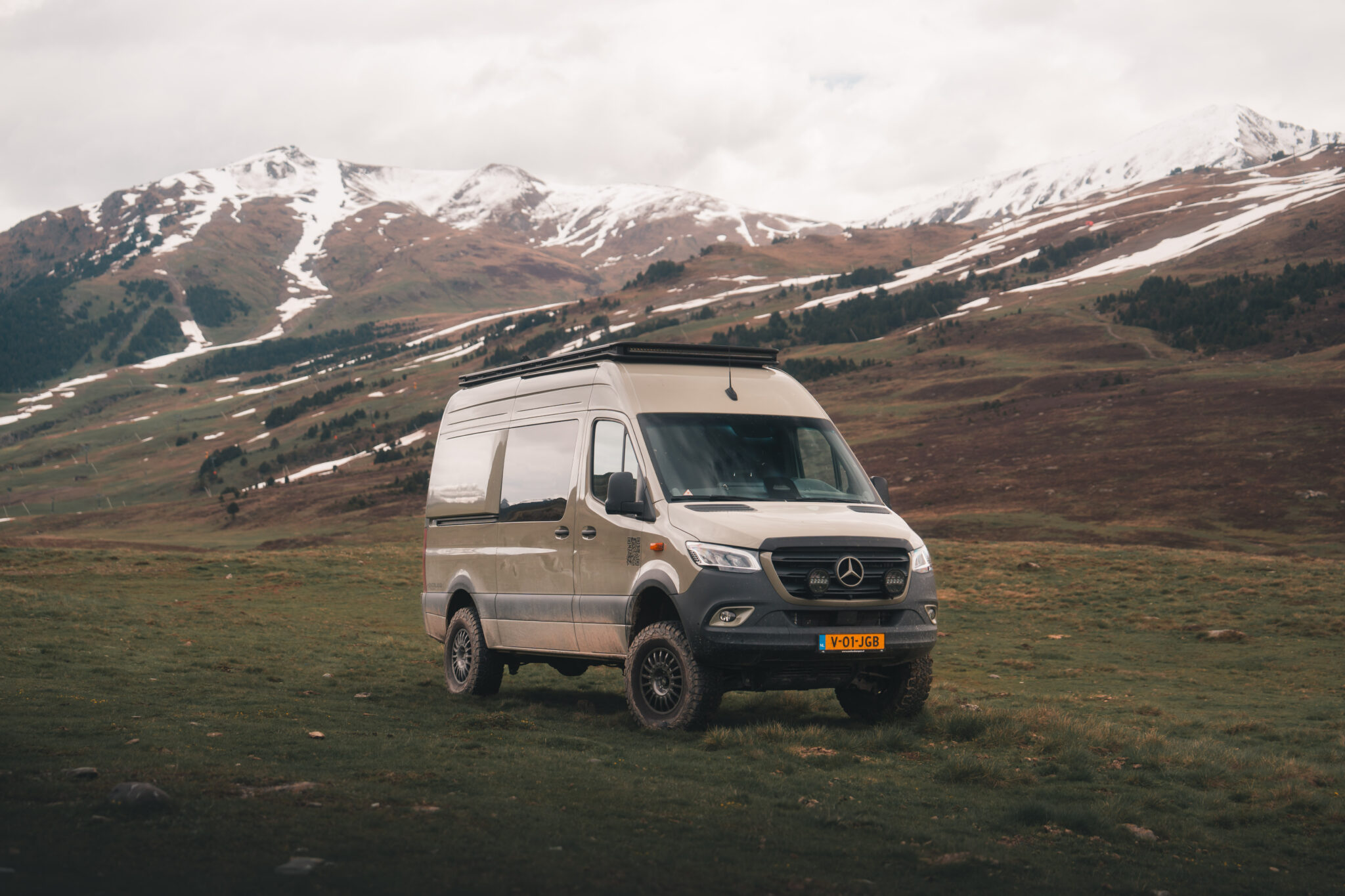 Overland Camper rijdend door een bergachtig landschap